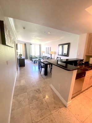 A spacious kitchen with a central island, a dining area with a table and chairs, and a living room with a sofa and a TV. - Luxury Las Vegas Strip!  2BR Condo ~ Sphere view ~ 24/7 Pool 3-24 (Las Vegas)
