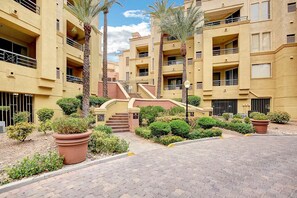 A multi-story residential building with a central staircase, surrounded by landscaped areas with potted plants and shrubs. - Luxury Las Vegas Strip!  2BR Condo ~ Sphere view ~ 24/7 Pool 3-24 (Las Vegas)