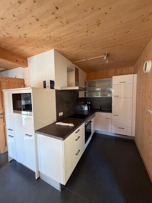 A modern kitchen with white cabinetry, a dark countertop, and a wooden ceiling. - 012 Mw21b in Murau (Murau)