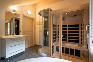 A modern bathroom with a white vanity, a glass shower enclosure, and a wooden shelving unit. - 002 MW5 in Murau (Murau)