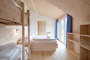 A room with bunk beds, a single bed, a window with curtains, and built-in shelves. - 002 MW5 in Murau (Murau)