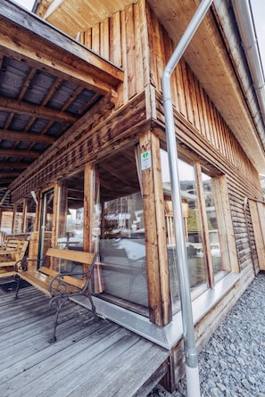 A wooden building with a covered porch, large windows, and a sign indicating a room number. - 026 W6 in St Georgen am Kreischberg (Sankt Georgen am Kreischberg)