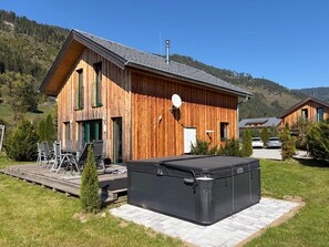 A wooden cabin with a deck, outdoor seating, and a hot tub. - 014 Mw23 in Murau (Murau)