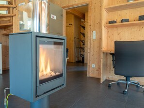 A modern interior with a fireplace, wooden walls, and a black office chair. - 001 MW1 in Murau (Murau)