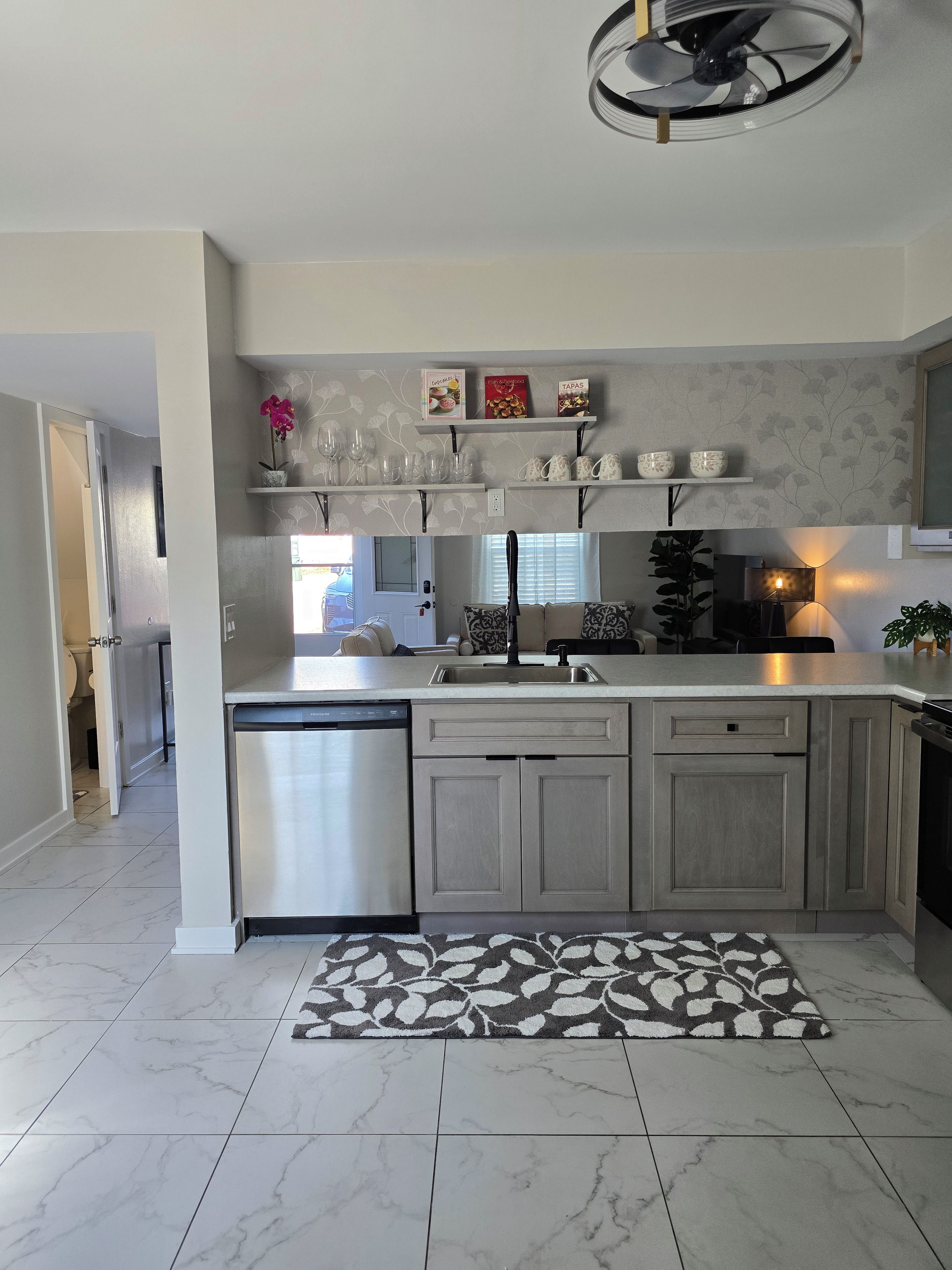Una cucina moderna con lavastoviglie, doppio lavello e un decorativo pannello di rivestimento.