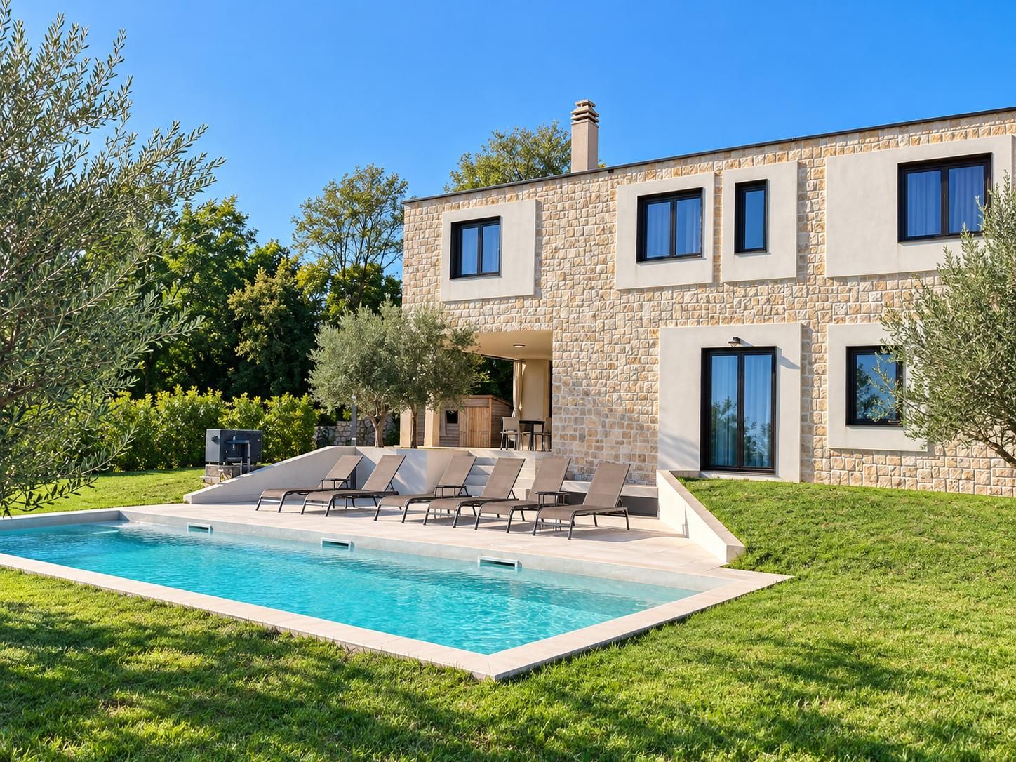 A modern two-story house with a swimming pool and outdoor seating area.