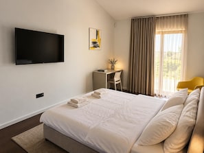 A hotel room with a bed, a desk, a chair, a television, and a window with curtains. - Villa Casa Venus - Three Bedroom Villa, Sleeps 6 (Sveti Ivan)