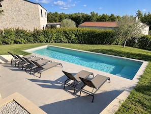 A rectangular swimming pool with a tiled deck, surrounded by a hedge and a stone building. - Villa Casa Venus - Three Bedroom Villa, Sleeps 6 (Sveti Ivan)