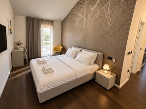 A modern hotel room with a large bed, bedside tables, a desk, and a chair. - Villa Casa Venus - Three Bedroom Villa, Sleeps 6 (Sveti Ivan)