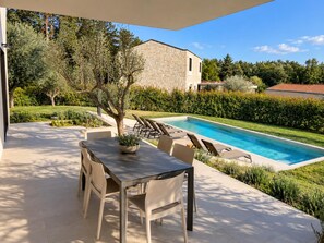 A poolside area with a dining table and chairs, a stone building in the background, and a well-maintained garden. - Villa Casa Venus - Three Bedroom Villa, Sleeps 6 (Sveti Ivan)