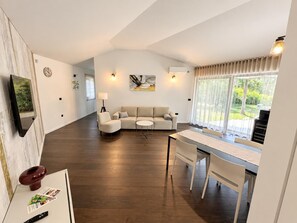 Een moderne woonkamer met een bank, een eettafel en een televisie.