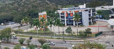 A modern building with a prominent GSK sign, surrounded by palm trees and a mountainous backdrop.