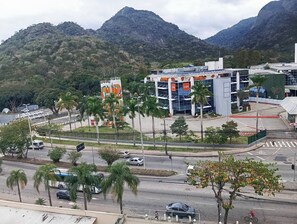 A modern building with a prominent GSK sign, surrounded by palm trees and a mountainous backdrop.