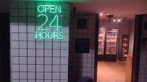 A neon sign indicating the establishment is open 24 hours.