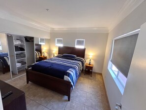 A bedroom with a bed, bedside lamps, a wardrobe, and a window. - Luxury Las Vegas Strip!  1BR Private Residences Penthouse Condo ~ 24/7 Pool 7-40 (Las Vegas)
