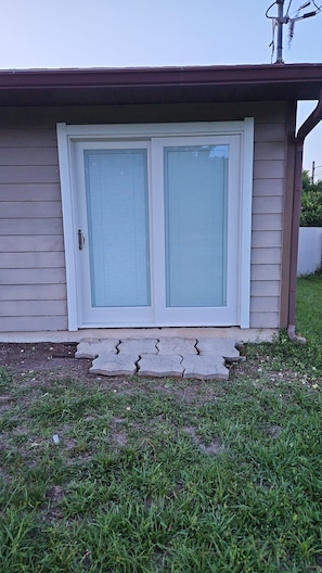 A house with a garage door and a small porch area. - Cozy 1-bedroom in tranquil Kissimmee with private entrance (Kissimmee)