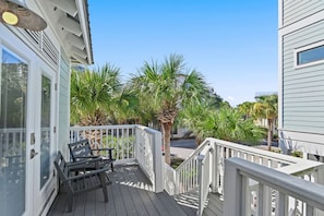 A balcony with a white railing, a bench, and palm trees. - ⭐Palms By The Sea | Rooftop Deck | Pool | Beach Access⭐ (Seacrest Beach)