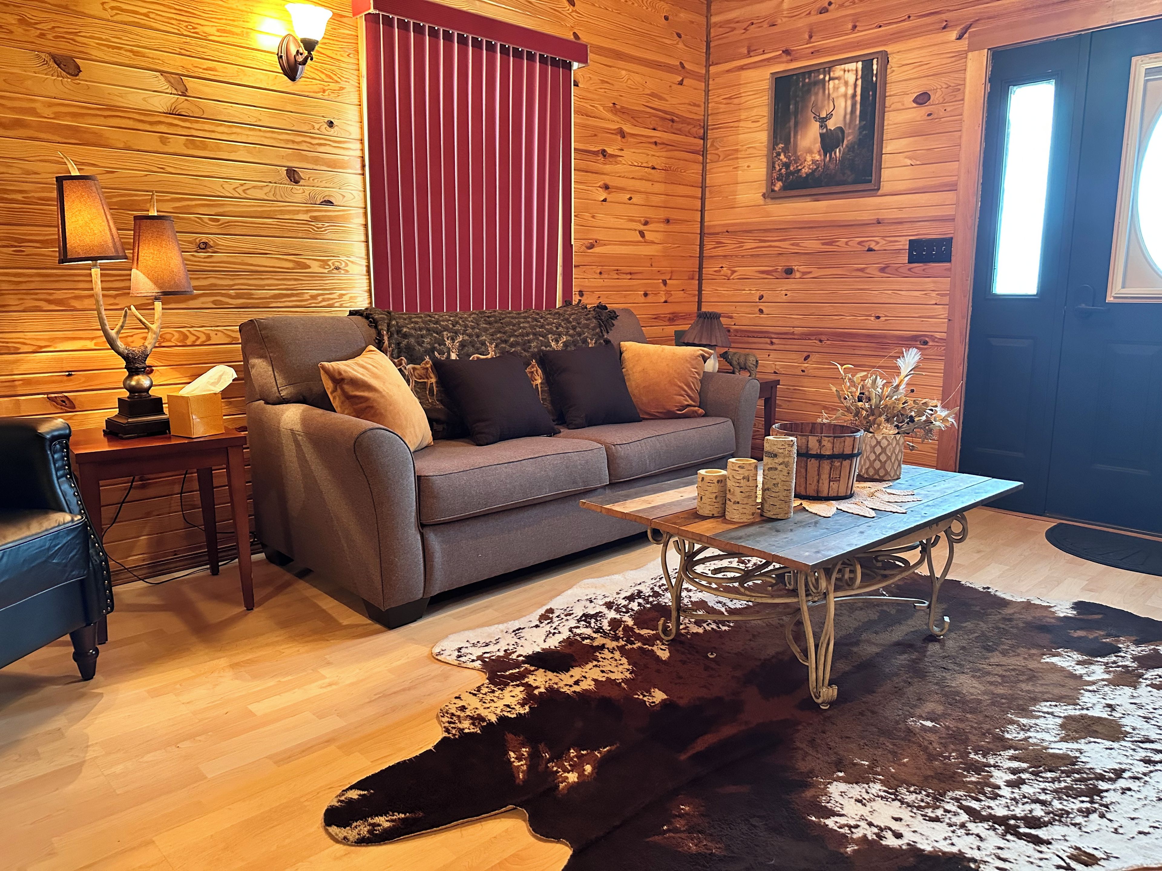 Una habitación acogedora con un sofá, una mesita de centro y una alfombra de cuero de vaca.