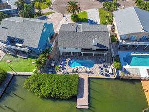 A residential property with a swimming pool, a dock, and a well-maintained lawn. - Luxury Waterfront Heated Pool Dock Golf Cart (Indian Rocks Beach)