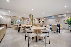 Ein modernes Wohnzimmer mit Essbereich, ausgestattet mit einem großen runden Tisch, Sofas und einem Couchtisch.