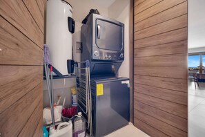 Eine kompakte Küchenzeile mit Kühlschrank, Mikrowelle und kleinem Backofen.