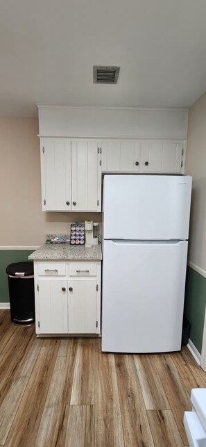 A kitchen with white cabinets, a double-door refrigerator, a coffee maker, and a trash bin. - Modern 2BR - King Bed - Pet-Friendly - Sleeps 6 (Boiling Springs)