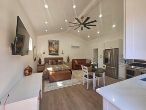 A modern apartment with a large bed, a dining area, and a kitchen. - Vaulted 12 ft ceilings studio gated with  private bathroom, W/D, walk in closet. (Los Angeles)