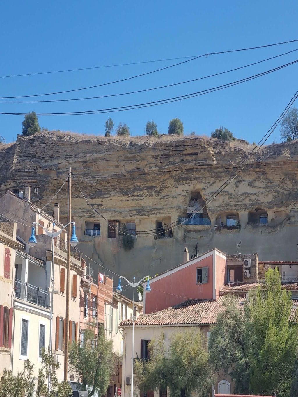 Zona residencial con edificios cerca de una ladera rocosa.