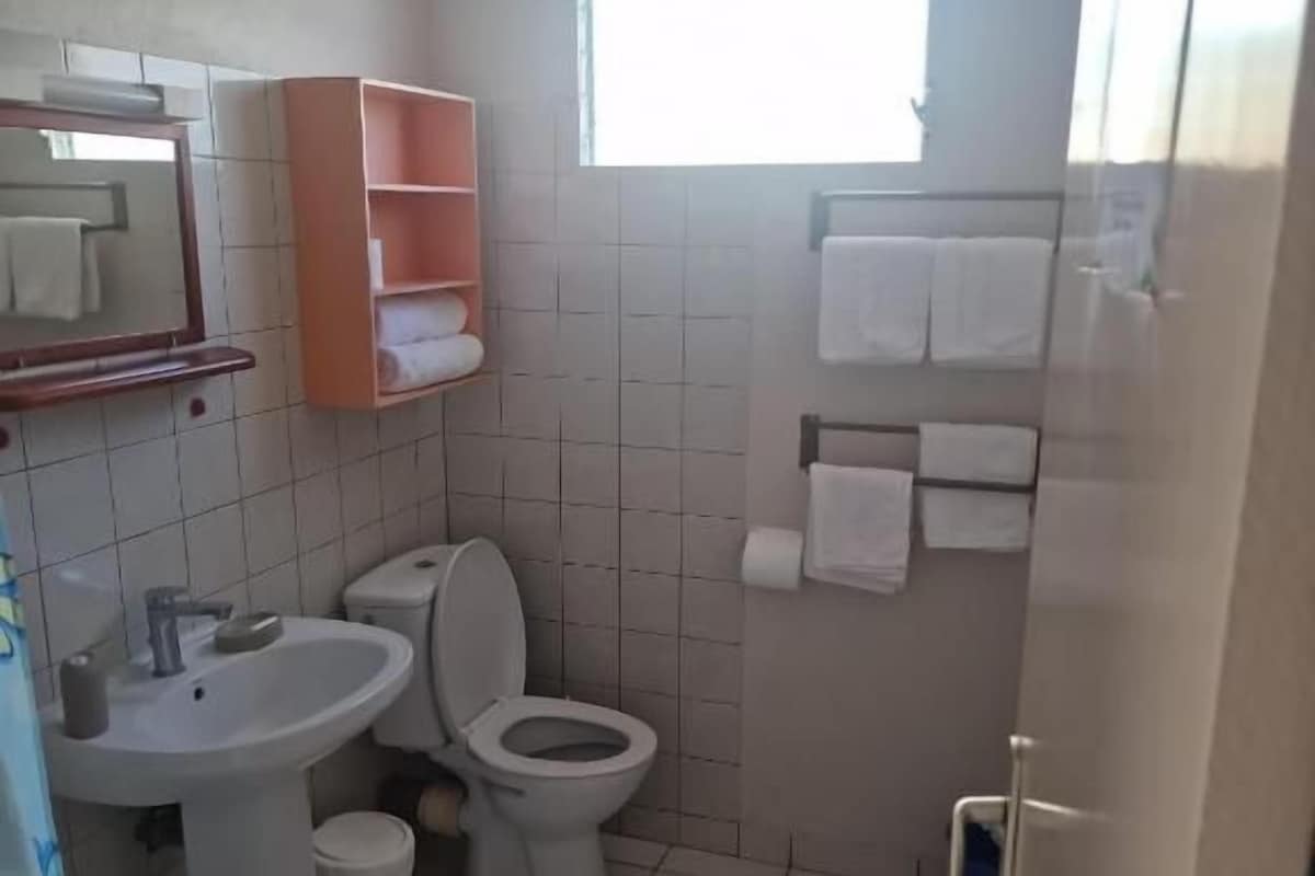 Un baño con lavamanos, inodoro y ventana.