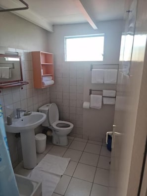 Un baño con lavamanos, inodoro y ventana.