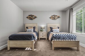A bedroom with two beds, a nightstand, and decorative wall art. - Delightful, walkable 4-bedroom family home (Coeur d'Alene)