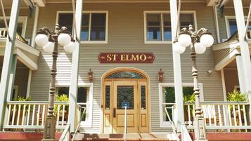Un edificio de dos pisos con un llamativo letrero de 'ST. ELMO' sobre la entrada.