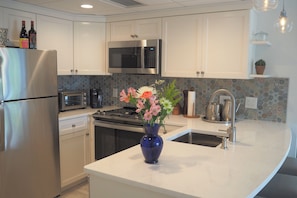 A modern kitchen with stainless steel appliances, a microwave, and a sink with a faucet.