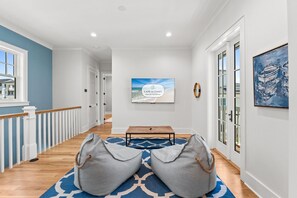 A hallway with a bench, a rug, and a framed picture on the wall. - Stunning 6 Bedroom Sugar Sands Home, Private Pool, Sleeps 14 (Mexico Beach)
