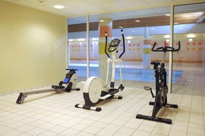 Ein Fitnessraum mit Ergometer, Rudergerät und Laufband.