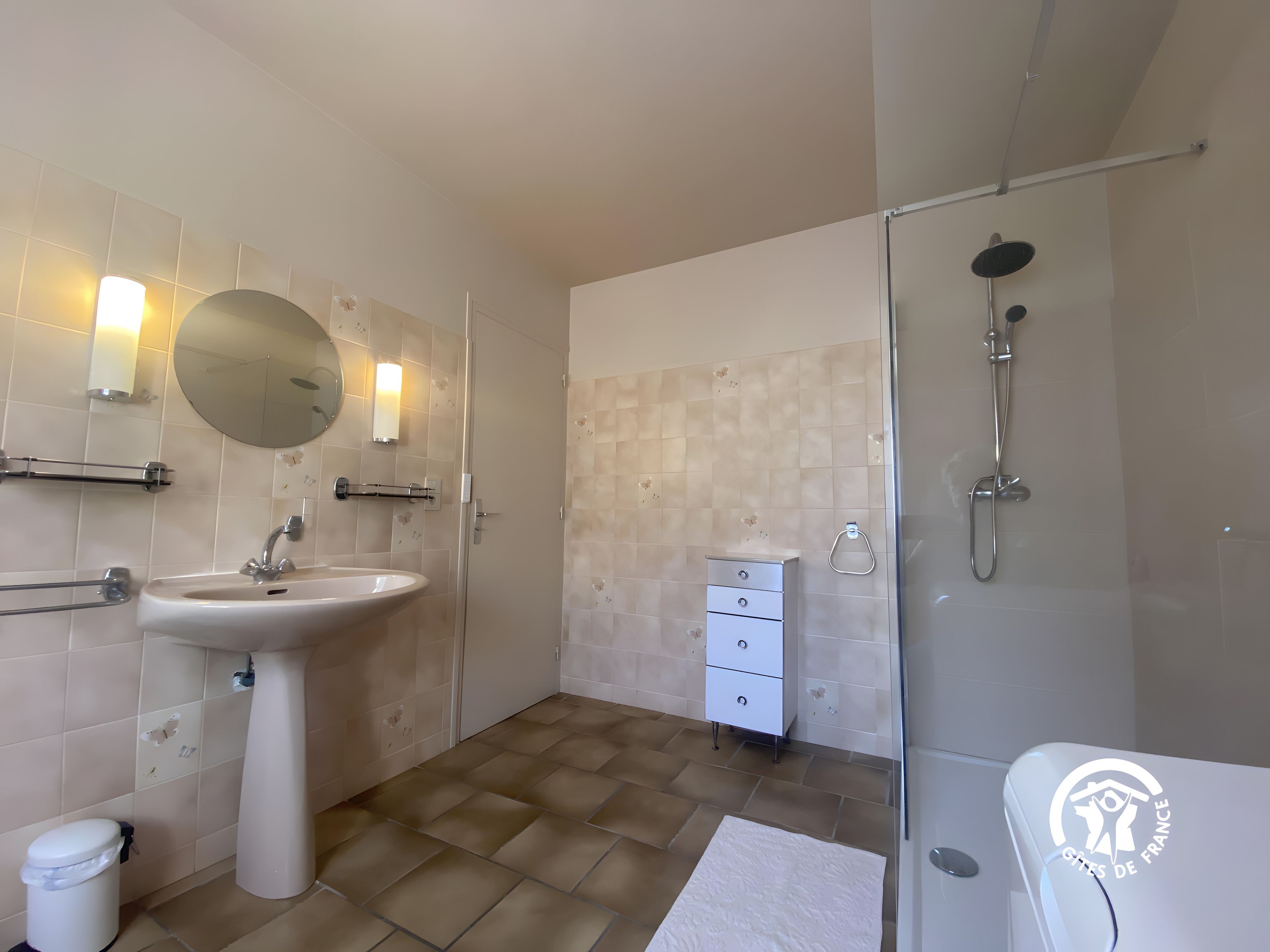 Un baño con lavamanos, espejo, toalla, inodoro y ducha.