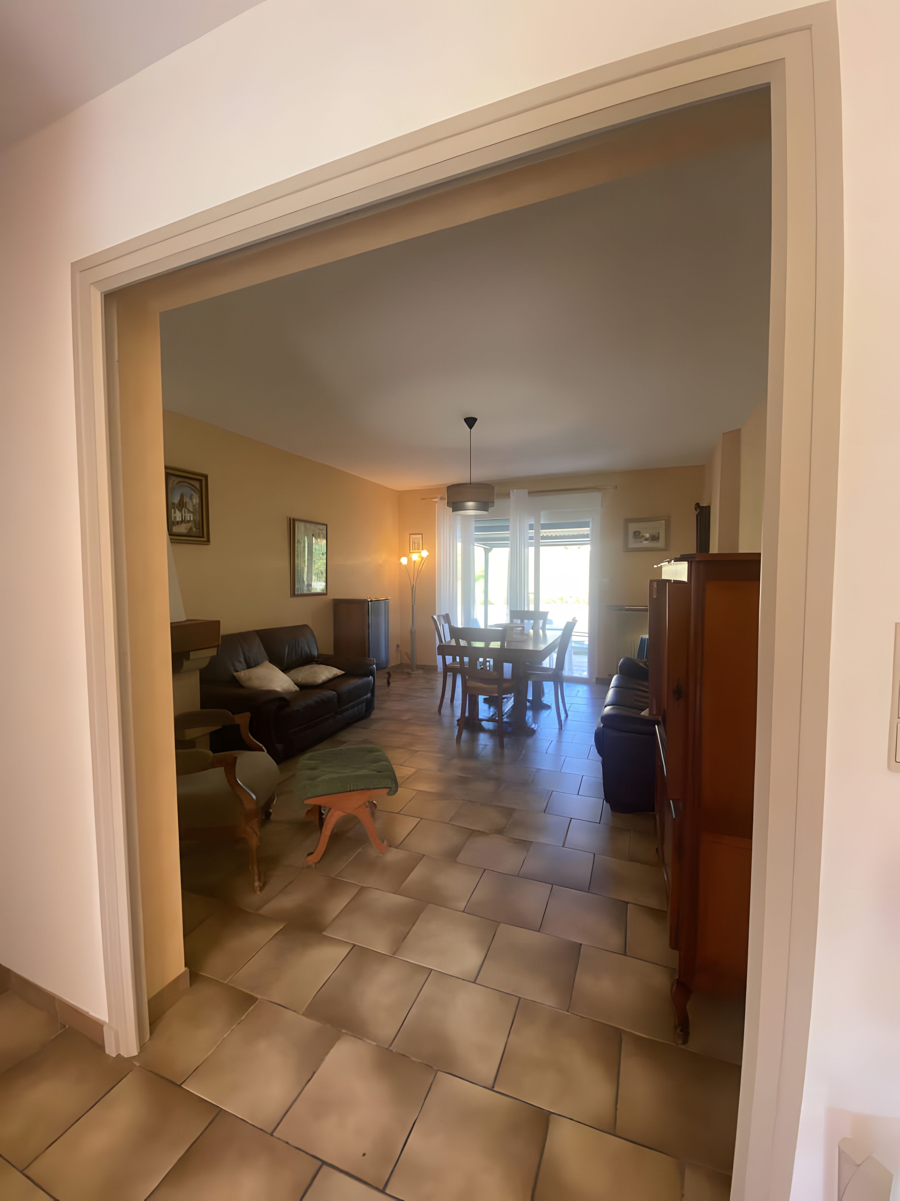 Un grand espace de vie comprenant un canapé, une table à manger avec des chaises et un escalier menant à un autre niveau.