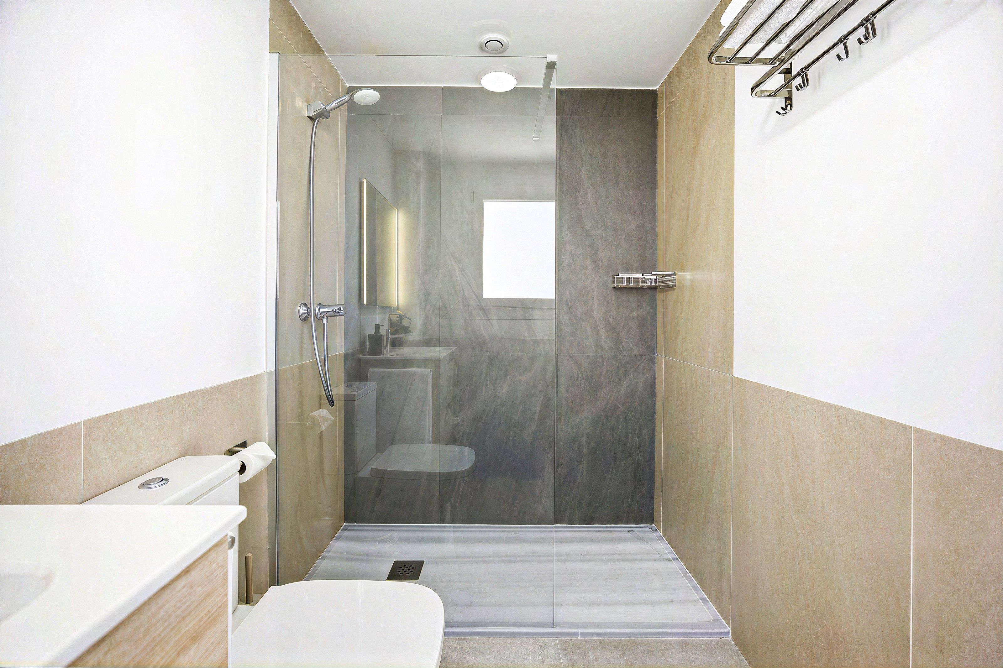 Une salle de bain moderne avec une douche à parois de verre, des toilettes et un lavabo.