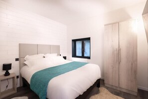 Ein Schlafzimmer mit einem Bett, einem Nachttisch, einem Fenster und einem Kleiderschrank.