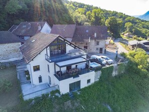 Ein modernes, zweistöckiges Haus mit Balkon und Whirlpool.
