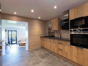 A modern kitchen with wooden cabinets, a black countertop, and a Siemens oven. - Les Terrasses du Lac -lake/mountain views, hot tub (Chanaz)