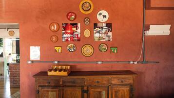 A wall with various decorative plates and a wooden cabinet below.