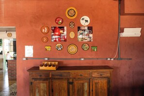 Un mur orné de différents types d’assiettes décoratives et, en dessous, un meuble en bois.