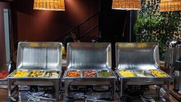 A buffet setup with various food items and utensils.