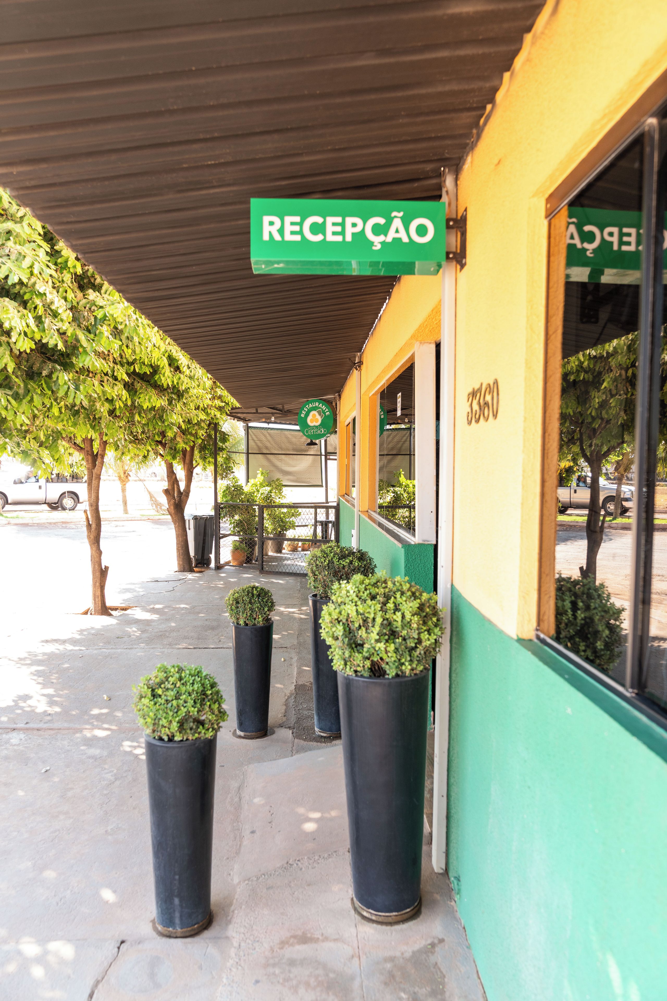 A building with a green sign reading 'RECEPCAO' and a number '3360' on the wall.
