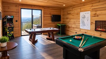 Une salle équipée d’une table de billard, d’un baby-foot et de jeux d’arcade.