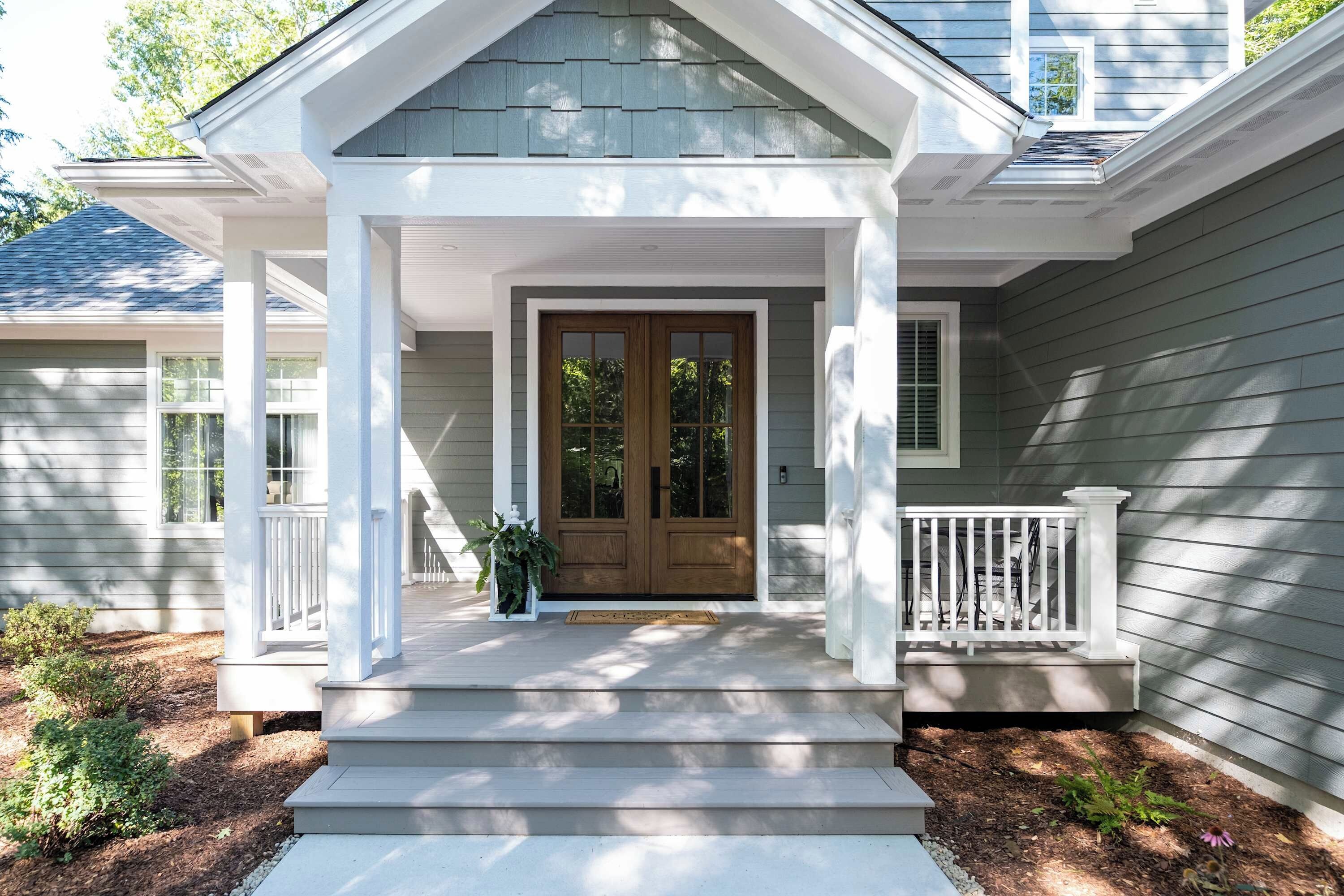 A house with a front porch, a double door, and a small window to the right.