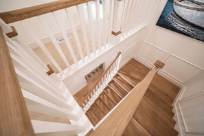 Una escalera con barandillas blancas y peldaños de madera.