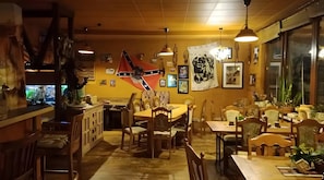 L’intérieur d’un restaurant, avec des meubles en bois, un drapeau et diverses décorations murales.