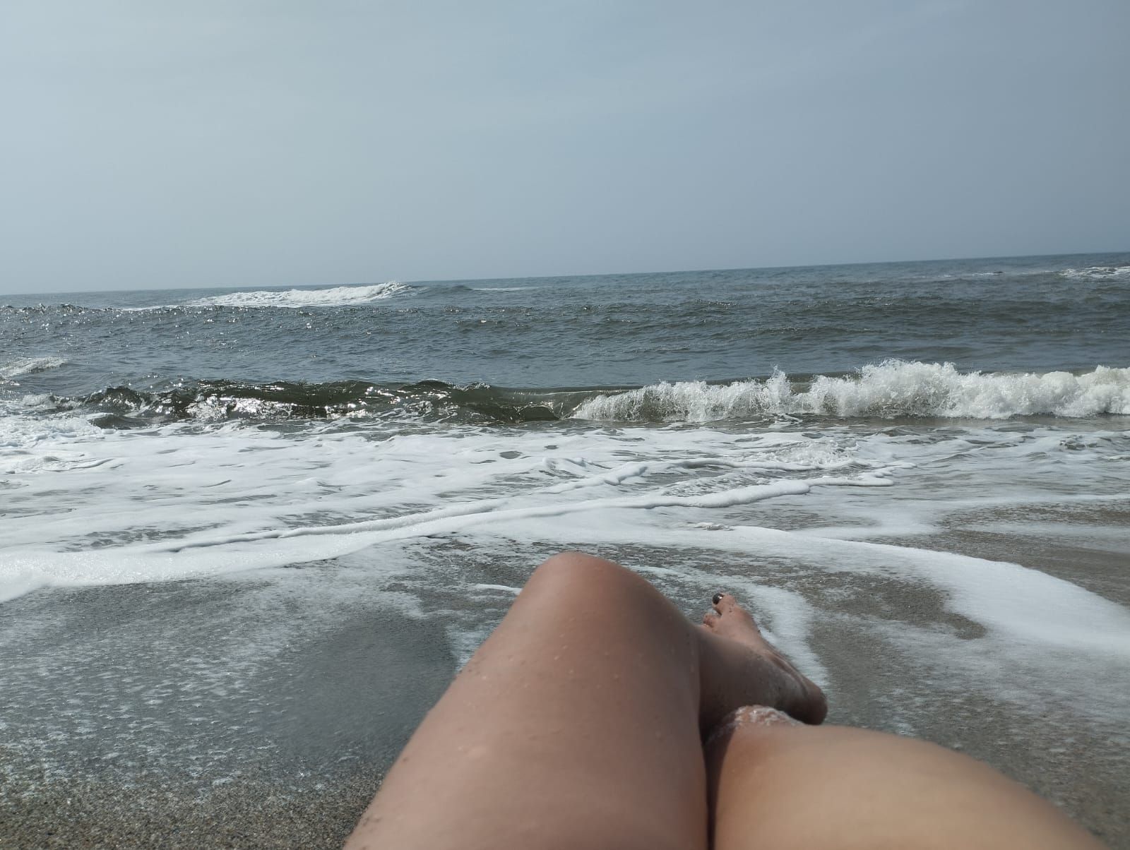 A beach scene with waves and a clear sky.